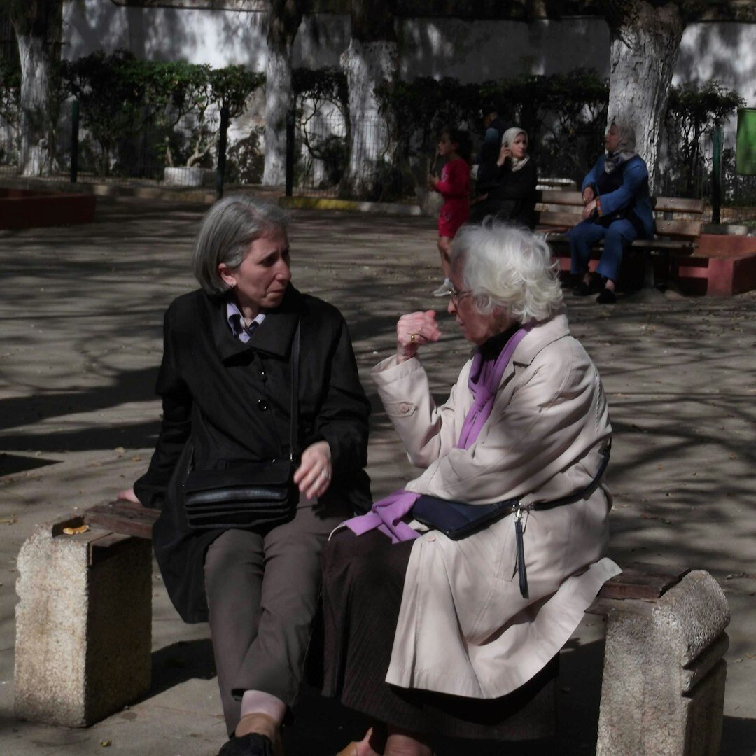 senior friends chatting in park