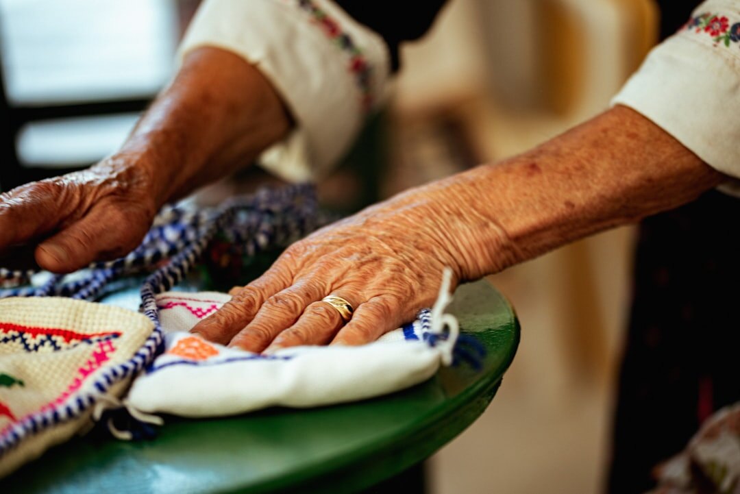 Elderly women doing handicrafts and knitting together at a table