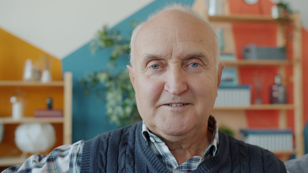 Portrait of a smiling elderly Swiss man with glasses and a sweater